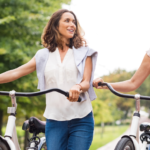 two white women walking bicycles