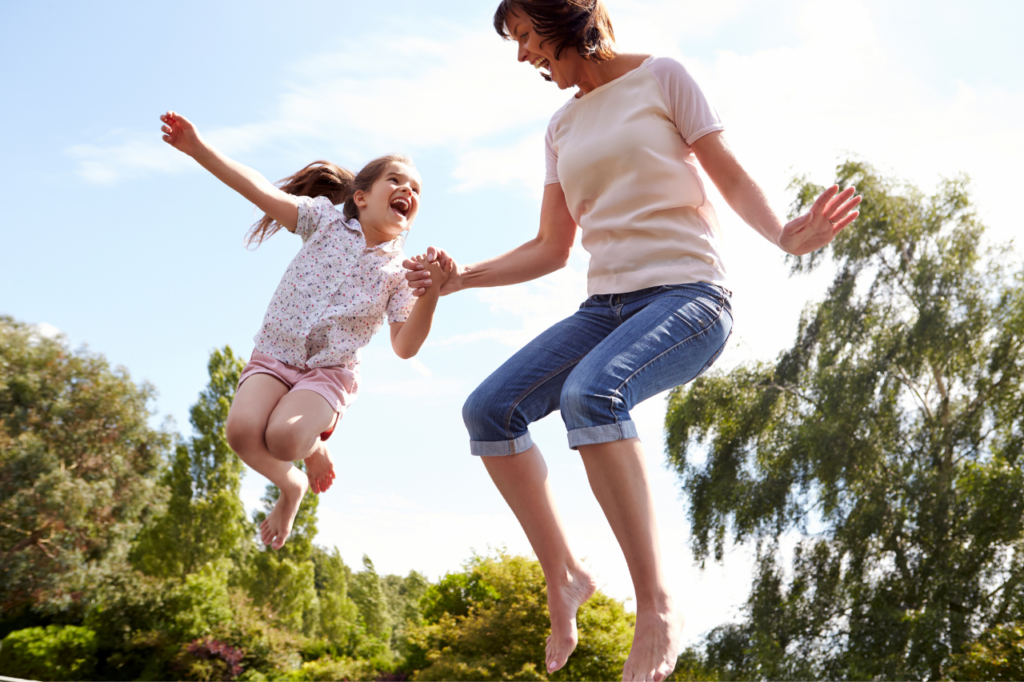 white woman and white little girl jumping on a trampoline