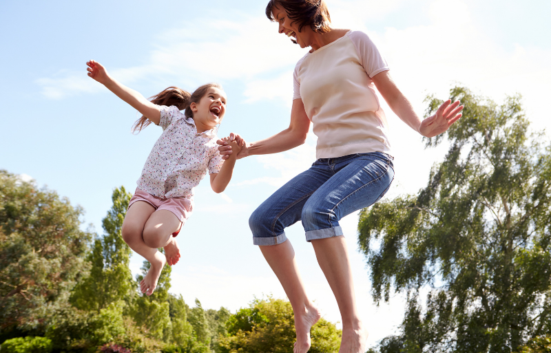 white woman and white little girl jumping on a trampoline